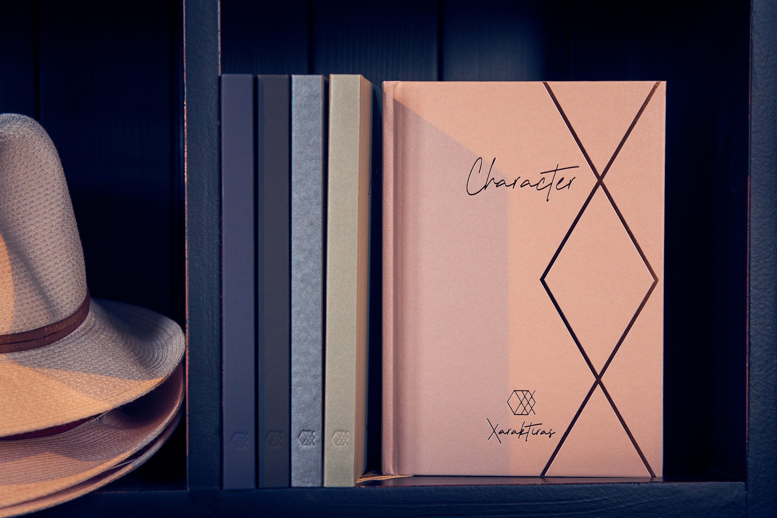 Xaraktiras Design-Notizbücher im Regal neben Hut